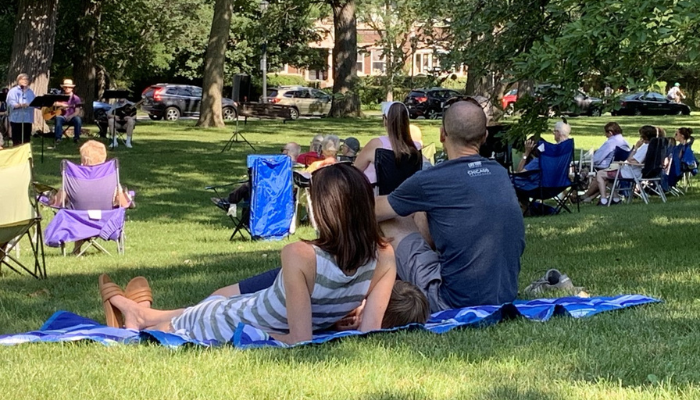 Family sits on blanket at Worship in the Park